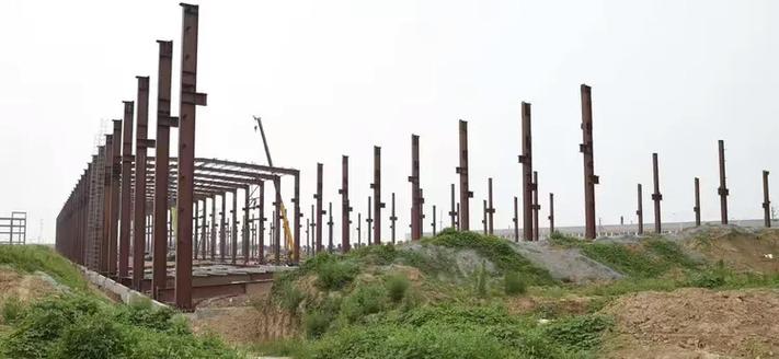 与工程监理了解工程进1#建筑中39米跨钢架即将合拢俯瞰整个扶风建设